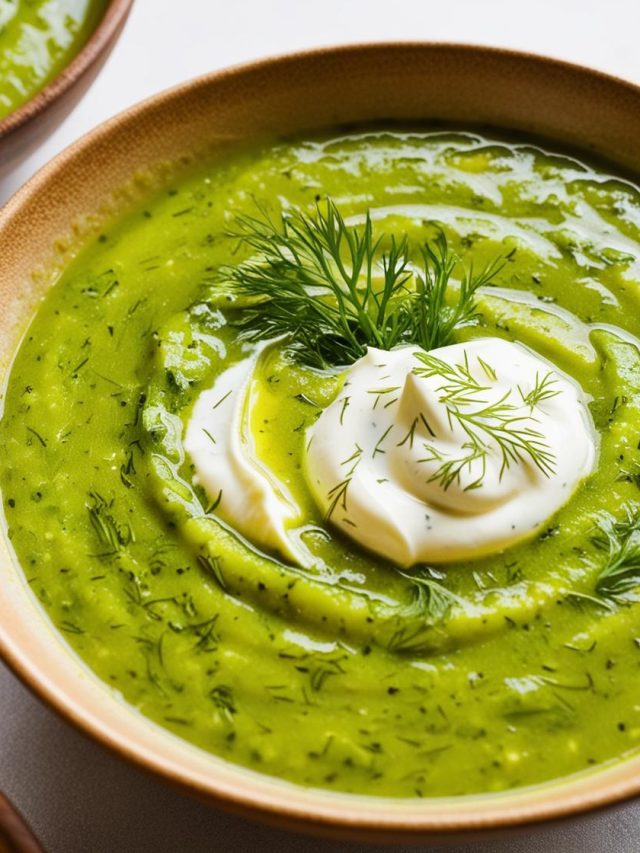 Homemade zucchini soup served in a bowl, garnished with fresh herbs. The soup has a creamy texture and vibrant green color, surrounded by ingredients like zucchini, garlic, and spices, showcasing its wholesome and fresh preparation.